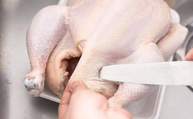 1. Этап. Запеченная курица с хрустящей корочкой: 3. Вырежьте отверстия в коже курицы справа внизу и слева внизу, в них будут вставляться куриные ноги.