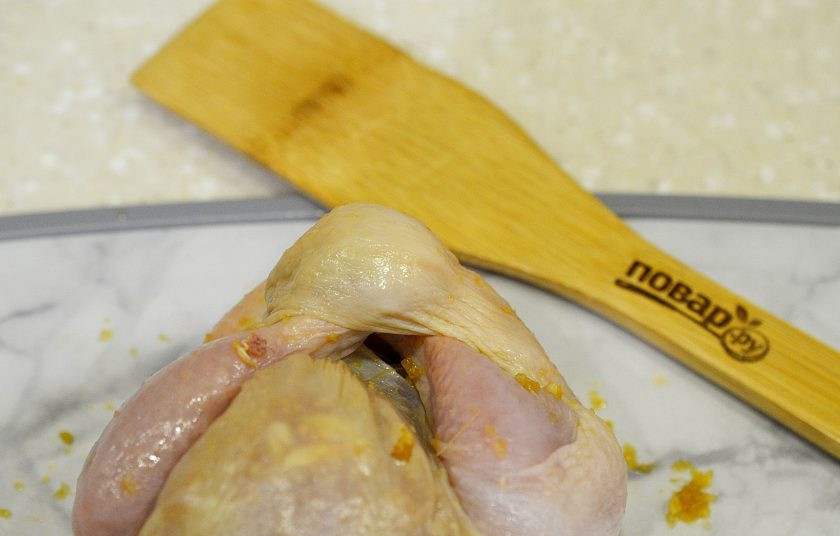 1. Этап. Курица, запеченная в беконе: 6. Подрежьте шкуру возле одной из ножек. Должна образоваться петелька. Вставляем в эту петельку сначала одну, а затем вторую ножку.
