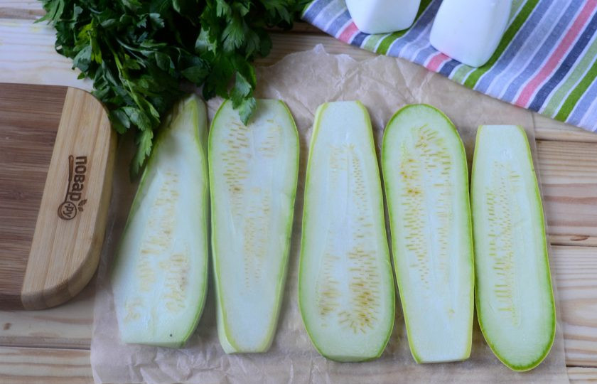1. Этап. Рулетики из кабачков с куриной грудкой: Кабачок порежьте вдоль на пластины толщиной 5-7 мм. Положите кабачковые пластины на противень, застеленный пергаментом, и отправьте в разогретую до 160 градусов духовку на 8-10 минут. За это время кабачок размягчится, и его легко будет свернуть в рулетик.