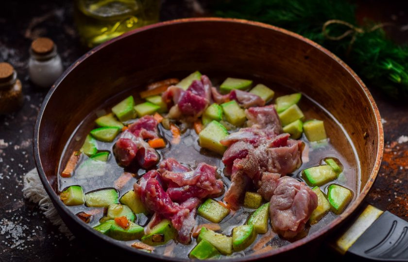 1. Этап. Тушеные куриные желудки с кабачками: Влейте в сковороду воду, добавьте специи. Прикройте сковороду крышкой и тушите 30 минут на небольшом огне.