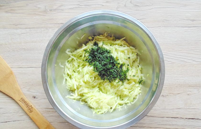 1. Этап. Оладьи из кабачков на ряженке: Кабачок вымойте и натрите на тёрке. Если он старый очистите от кожуры. Нарежьте мелко петрушку. Переложите кабачок и петрушку в глубокую миску.