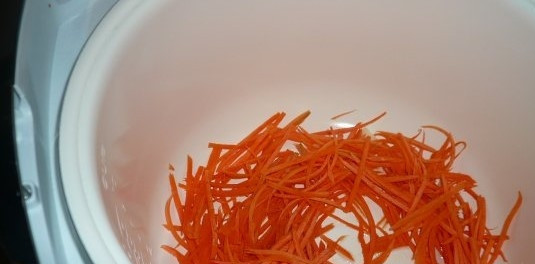 1. Этап. Куриная грудка с морковью: 2. Помойте и почистите морковь. Натрите ее на терке с крупным полотном. В чаше мультиварки хорошо разогрейте растительное масло. Затем переложите в горячее масло натертую морковь. Поджарьте.