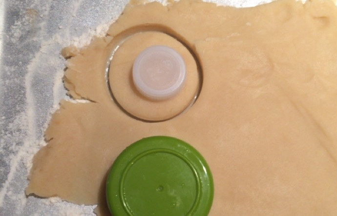 1. Этап. Песочное печенье с кокосом, карамелью и шоколадом: 9. Вырежьте крышкой или специальной формочкой небольшую медаль, а затем формочкой поменьше (можно крышкой) проделайте отверстия в каждой медальке.