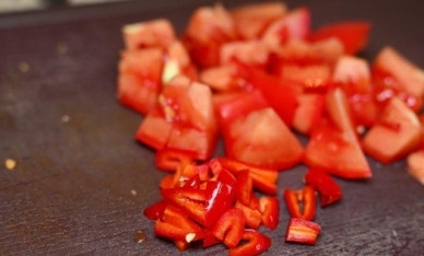 1. Этап. Говядина в кисло-сладком соусе по-китайски: Перец чили нарезаем тонкими колечками, а помидор — кусочками.