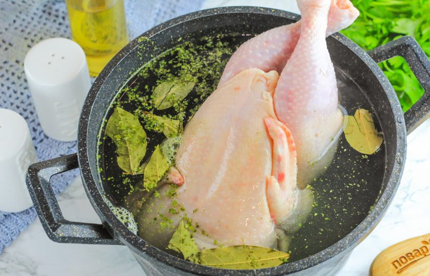 1. Этап. Отварная курица с чесночным соусом: Влейте горячую воду и поместите емкость на плиту. При закипании жидкости удалите образовавшуюся пену и отварите курицу примерно 1-1,5 часа до готовности на умеренном нагреве.