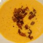 Тыквенный суп с беконом и кукурузой Тыкву (сорт Баттернат) помыть и порезать на куски. Сбрызнуть подсолнечным маслом и запечь в духовке до мягкости. Мякость срезать, пюрировать блендером. Полученного пюре понадобится стакан или чуть больше. Его нужно выложить в кастрюлю, развести овощным бульоном, всыпать кукурузу. Несколько минут поварить на небольшом огне. Влить сливки, размешать. посолить-поперчить.