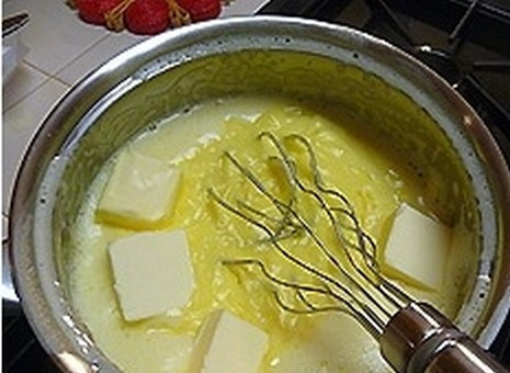 1. Этап. Заварной крем со сливками: Снимите кастрюльку с плиты, добавьте кубики сливочного масла.