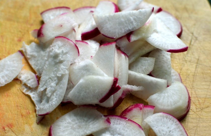 1. Этап. Летний салат с редисом и черемшой: Вымытую редиску нарежьте тонкими ломтиками и выложите в миску.