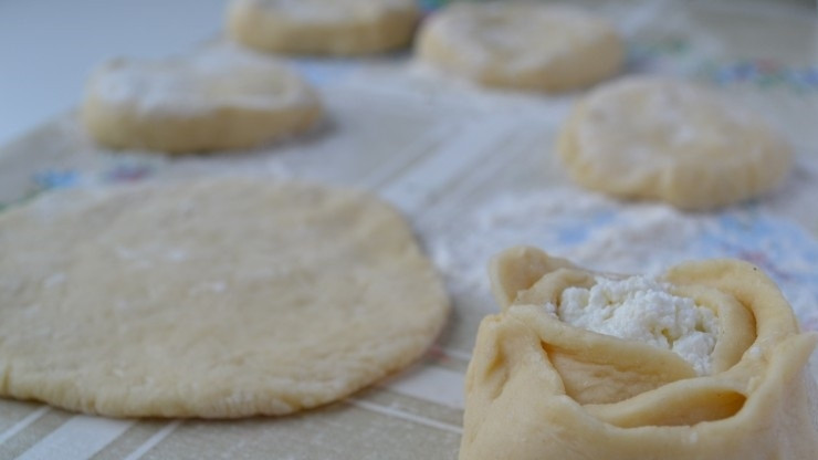 1. Этап. Ватрушка на кефире: 3. Готовое тесто разделяю на 10 частей, раскатываю каждую, внутрь кладу начинку, затем оставшиеся края немного надрезаю и загибаю в виде цветка.