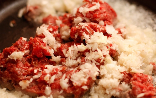 1. Этап. Кесадилья с фаршем: 3. На разогретую сковородку влейте растительное масло. Затем выложите фарш и лук. Обжаривайте, пока мясо не изменит цвет и лук не станет прозрачным. Добавьте перец чили, который предварительно освободите от семян и мелко порежьте.