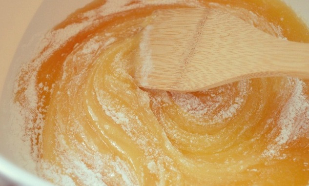 1. Этап. Козинаки из грецких орехов: Далее мы выкладываем мед в толстостенную кастрюльку и смешиваем его с сахарной пудрой.