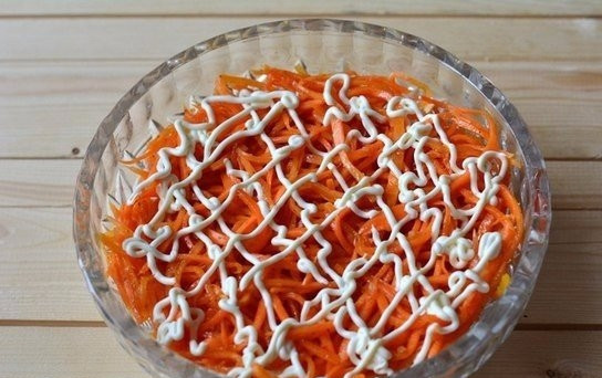 1. Этап. Салат слоями с курицей: Поверх курицы выложите морковку по-корейски. Покройте второй слой майонезом.