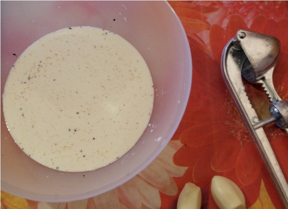 1. Этап. Мясо в чесночном соусе: Готовим соус. Для этого смешиваем в мисочке сливки с приправами, добавляем по щепотке соли и перца и измельченный чеснок.