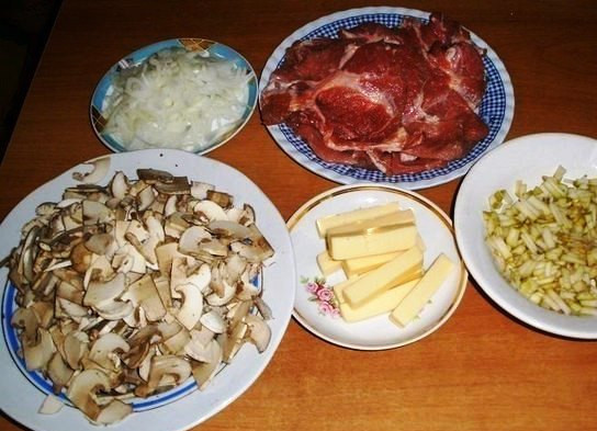 1. Этап. Мясо, фаршированное грибами и сыром: Свинину нарежьте тонкими кусками и хорошо отбейте. Также порежьте груши, грибы, лук и сыр.