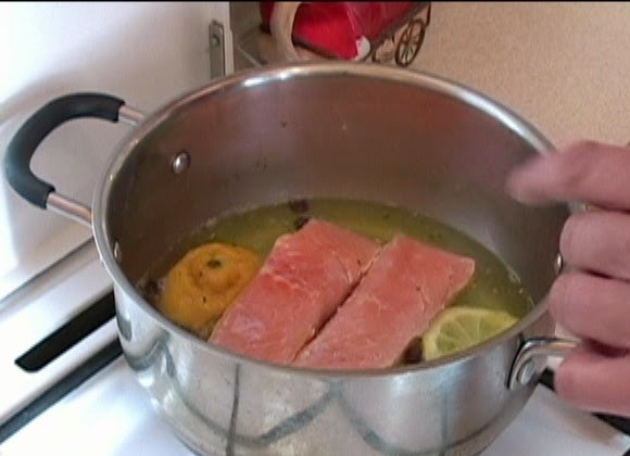 1. Этап. Спагетти с лососем в сливочном соусе: В небольшую кастрюлю или сотейник влейте 1 стакан воды, доведите до кипения, добавьте соль, куриный или овощной бульон, душистый перец, лавровый лист, выжмите сок из половинки лимона, лимон тоже опустите в воду. Перемешайте, добавьте ломтики рыбы и варите при слабом кипении 7-10 минут. Затем переверните рыбу и варите еще 5 минут.