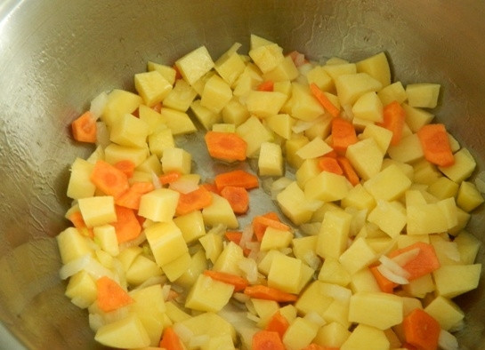 1. Этап. Картофельный суп-толчeнка с квашеной капустой: 5. Разогреваем в другой кастрюле 2 ст. ложки масла и добавляем картошку, лук и морковку и на сильном огне обжариваем эти овощи несколько минут.