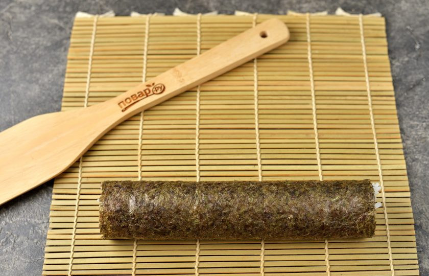 1. Этап. Роллы с икрой мойвы: Скрутите заготовку в ролл с помощью циновки. Выложите роллы на стык, чтобы водоросли хорошо склеились.