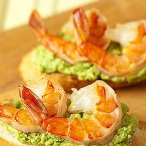 1. Этап. Брускетта с зеленым горошком и креветками: Багет обжариваем в тостере или на сухой сковороде, сразу же натираем одним зубчиком чеснока. Наверх выкладываем пасту из зеленого горошка и тигровые креветки. Подаем к столу сразу же. Брускетта готова!