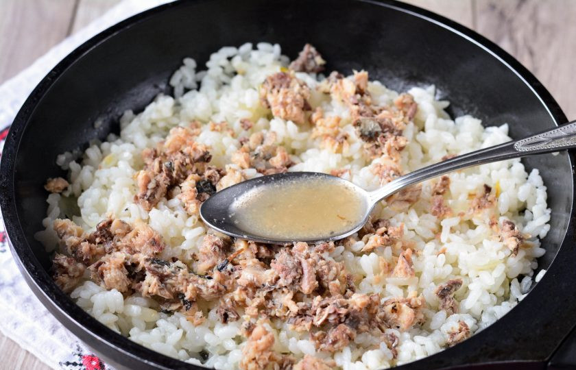 1. Этап. Рис с рыбными консервами: Добавьте консервы к рису, влейте пару ложек масла из консервов, чтобы блюдо стало более сочным. Готовьте рис еще 2-3 минуты под крышкой на тихом огне.