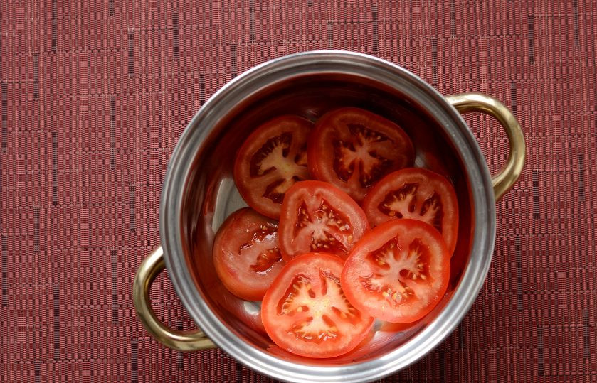 1. Этап. Закусочные помидоры: На дно кастрюли или глубокой миски выложите помидоры в один слой.