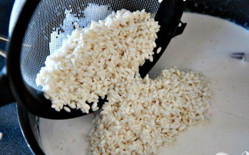 1. Этап. Рисовый десерт с изюмом: 3. Слить воду с риса и добавить в кастрюлю. Перемешать и довести до кипения на среднем огне.