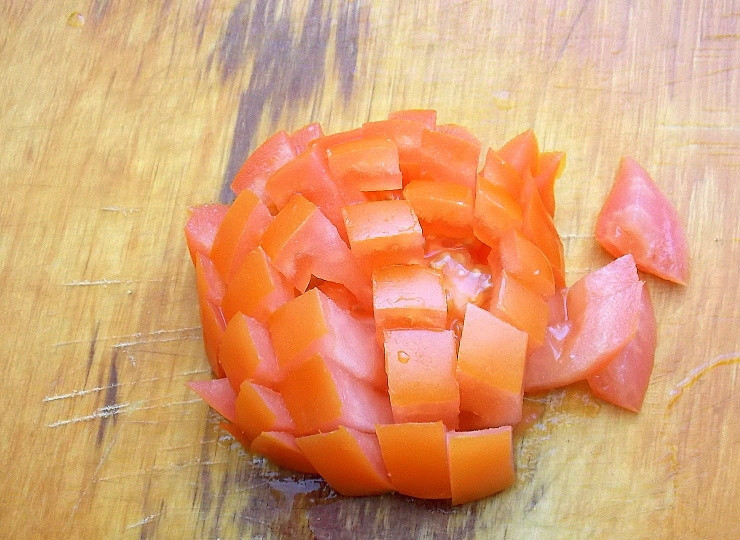 1. Этап. Щупальца кальмара в банке: Затем уберите пленку, которая отойдет, остальное оставьте. Порежьте помидор на кусочки. Добавьте к щупальцам.