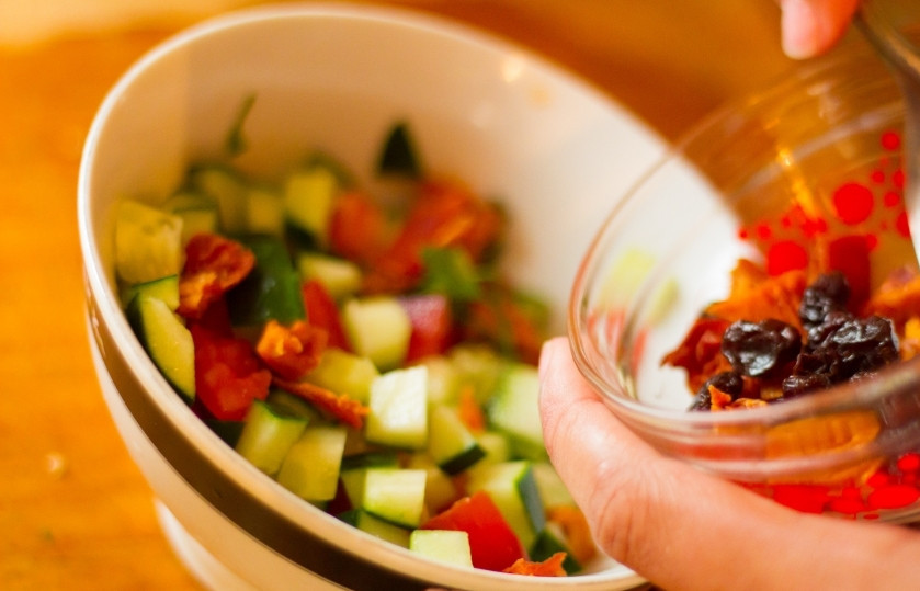 1. Этап. Салат Рыжая красавица: Нарежьте небольшими кусочками вяленые помидоры, огурец и финики.