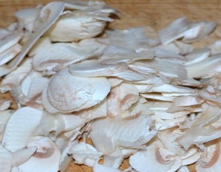 1. Этап. Салат с сырыми шампиньонами: Очистите шампиньоны и нарежьте их очень тонко с помощью терки-мандолины или острым ножом.