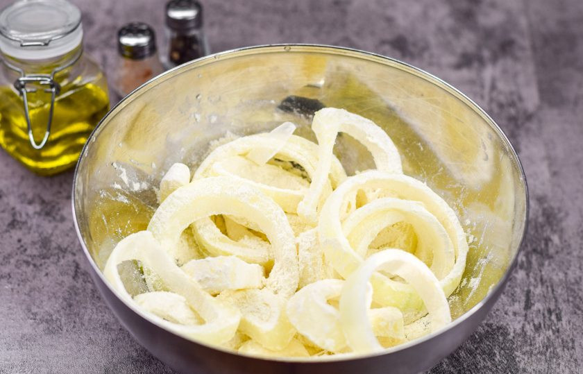 1. Этап. Лук в кляре к пиву: В отдельной глубокой миске соедините лук и оставшиеся две ложки пшеничной муки, щепотку соли. Хорошенько все стряхните, чтобы каждое луковое кольцо покрылось мукой.