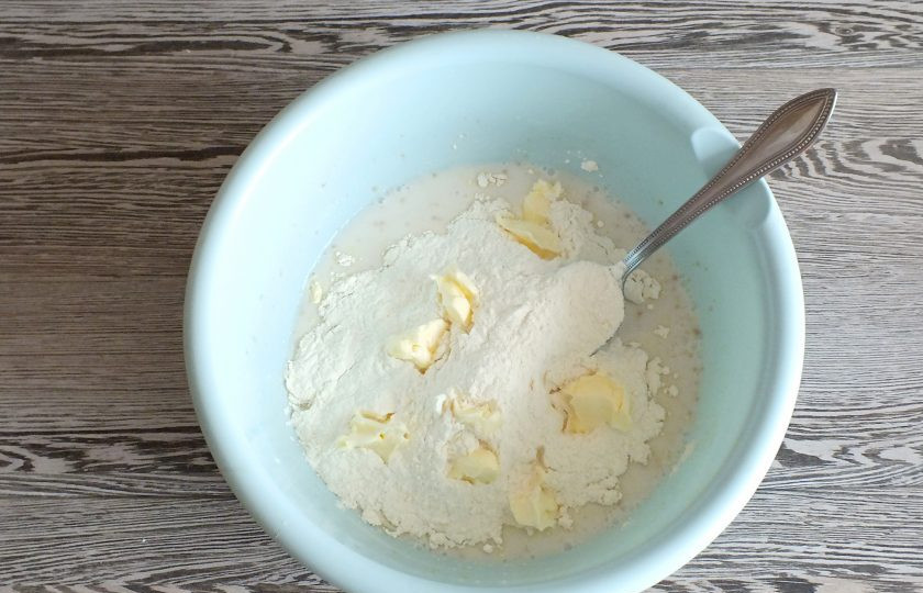 1. Этап. Ватрушки с бананом: Добавьте мягкое сливочное масло, половину указанного количества муки.