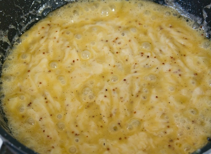 1. Этап. Гренки с сыром: 4. Сырную смесь снимите с огня, добавьте горчицу, посолите (по желанию), поперчите, введите желтки. Все перемешайте.