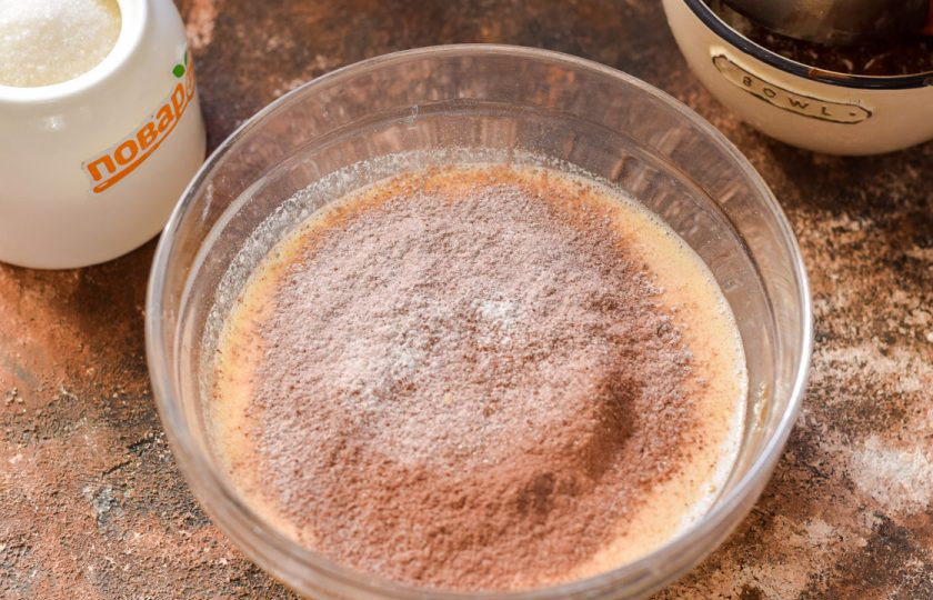 1. Этап. Торт Мираж: Частями просеивайте муку и какао в нашу жидкую основу, перемешайте тесто лопаткой.