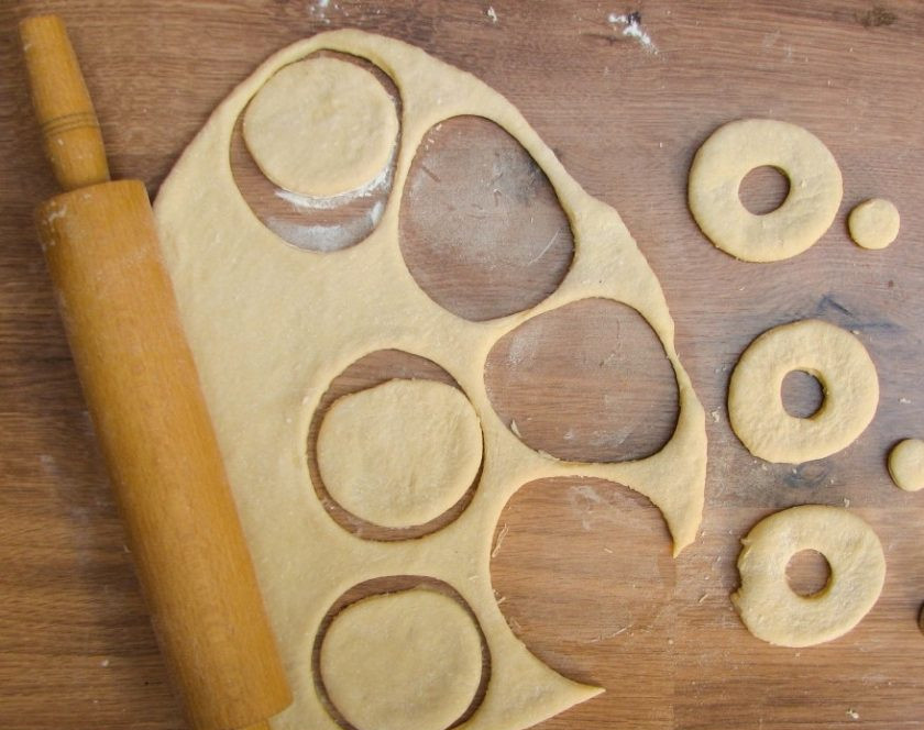1. Этап. Пончики классические: 4. Когда тесто подошло, выкладываем его на стол и делим на части. Затем раскатываем каждую часть и вырезаем круги. В середине каждого круга тоже вырезаем отверстие (я это делала при помощи наконечника от кондитерского шприца).
