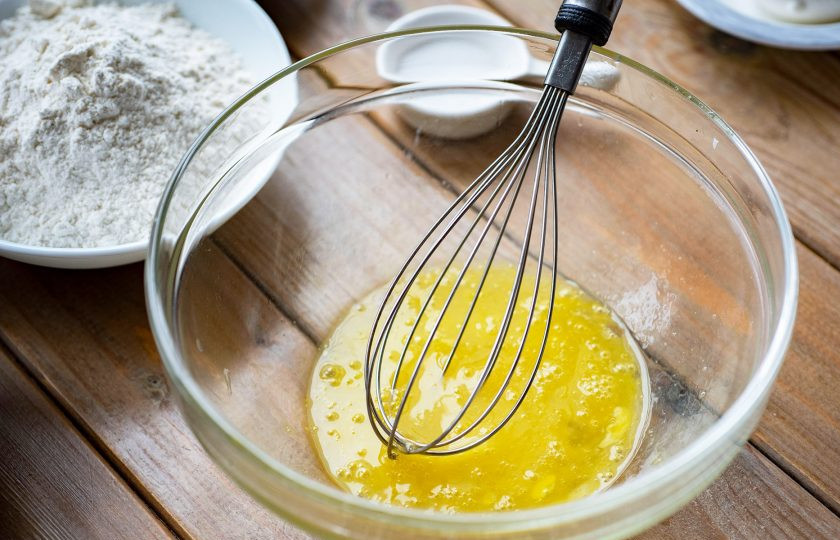 1. Этап. Пицца с оливками и креветками: Приготовьте тесто для основы. В миску вбейте яйцо, добавьте соль и активно перемешайте венчиком эти ингредиенты.