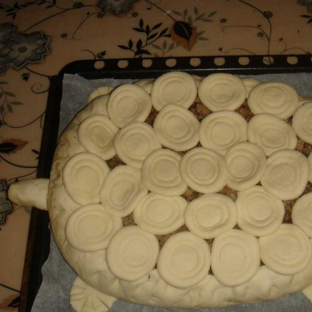 1. Этап. Пирог ЧЕРЕПАШКА: На основном пироге загибаем края, слегка приподнимая их и защипывая. Верх пирога укладываем кружочками, в форме панциря. Укладываем пирог на противень, выстланный пекарской бумагой.