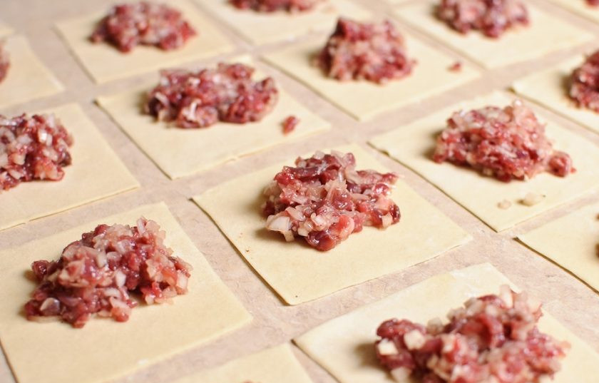 1. Этап. Настоящие манты: Тесто раскатайте тонким слоем и разрежьте на квадраты примерно по 10 см. В центр каждого квадратика положите фарш.