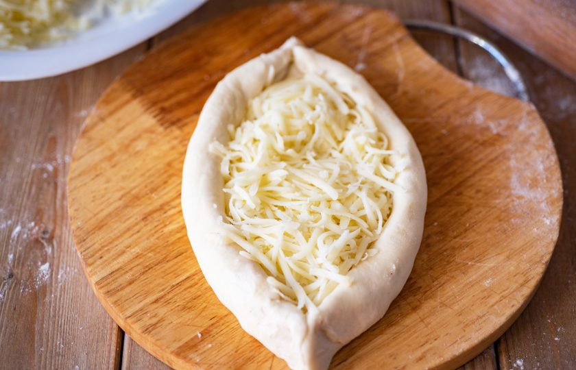 1. Этап. Хачапури по-аджарски на кефире: Каждую лодочку из теста заполните тертым сыром.