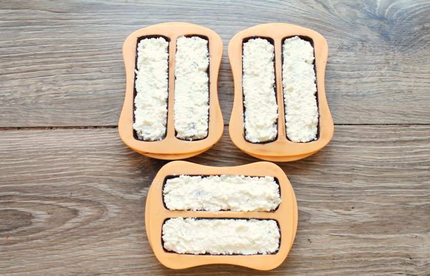 1. Этап. Глазированные сырки со сгущенкой: Закройте начинку из сгущенки оставшейся творожной массой и разровняйте.