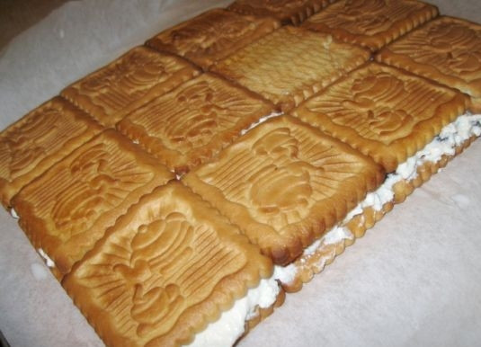 1. Этап. Торт с печеньем и творогом: 5. Поверх творога выложите половину оставшегося печенья. Тут уже не делайте отступы, а укладывайте плотно друг к другу.