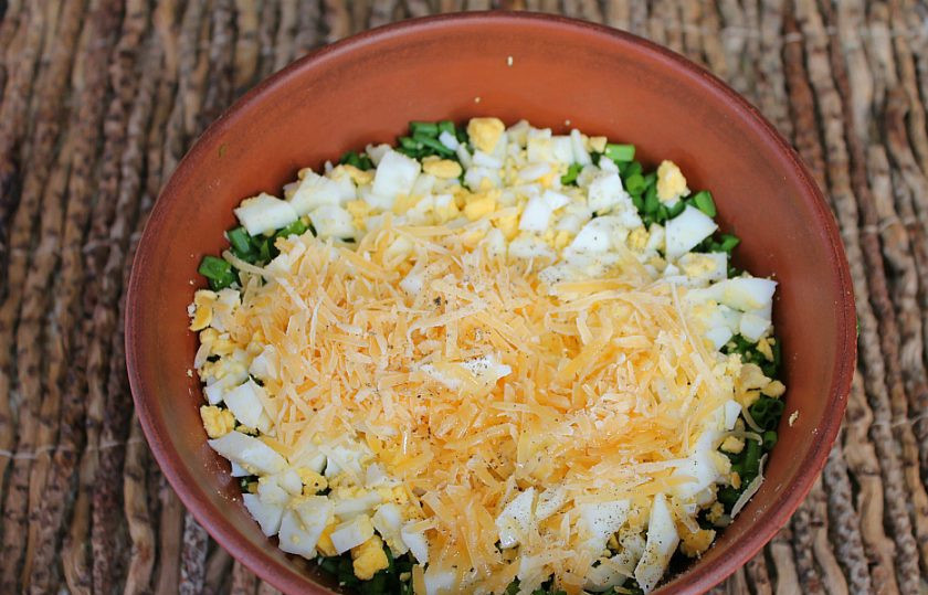 1. Этап. Чуду с зеленым луком: Насыпаем в начинку тертый сыр, молотый перец и добавляем ложку подсолнечного масла. Все перемешиваем.