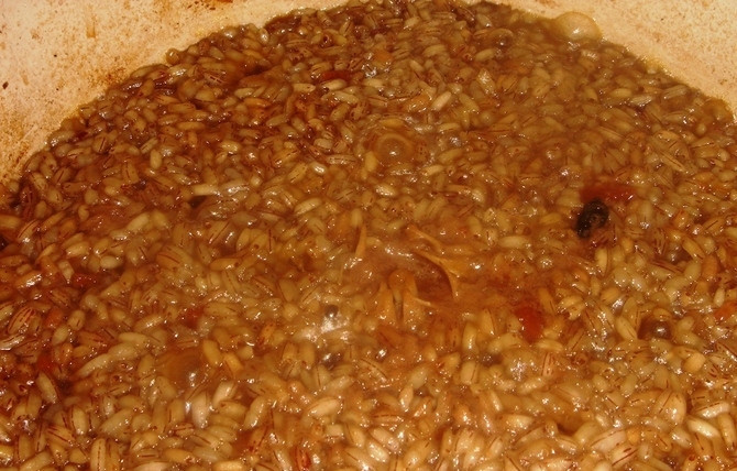 1. Этап. Плов с чесноком: Теперь всыпаем рис и равномерно распределяем его по всей поверхности, а затем аккуратно вливаем воду так, чтобы она была на 1,5-2 сантиметра выше риса. Пробуем на соль и специи и при необходимости добавляем. Когда жидкость закипит, готовим плов на среднем огне до испарения воды. Затем уменьшаем огонь до слабого, рис собираем с баков к середине горкой, чтобы чеснок был внутри ее, накрываем кастрюлю крышкой и готовим еще 20-25 минут.