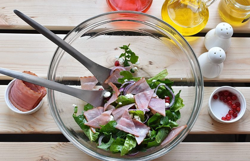 1. Этап. Салат с персиками: Добавьте тонко нашинкованный красный лук, нарезанные удобными кусочками ломтики ветчины, раскрошите сыр и добавьте смородину. Полейте еще заправкой и легко перемешайте.