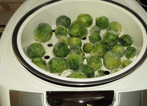 1. Этап. Брюссельская капуста на пару в мультиварке: 1. В чашу мультиварки налейте воду и установите контейнер для приготовления на пару. Выложите капусту. Можно взять как свежую, так и замороженную.