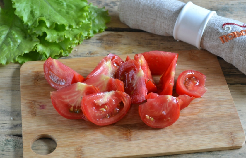 1. Этап. Салат Цезарь с курицей и сухариками: 4. Помидор очистите и порежьте нетолстыми дольками.