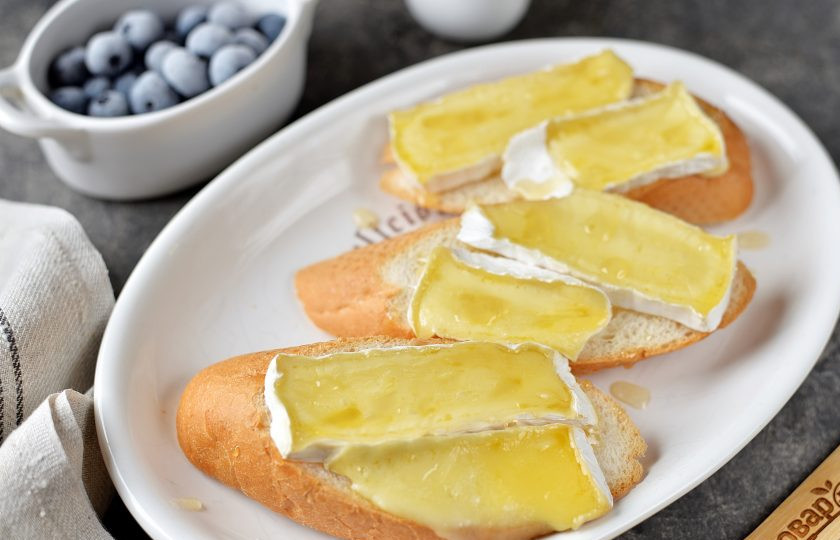 1. Этап. Тост с голубикой и сыром Бри: Переложите тосты на плоскую тарелку, полейте их жидким медом.