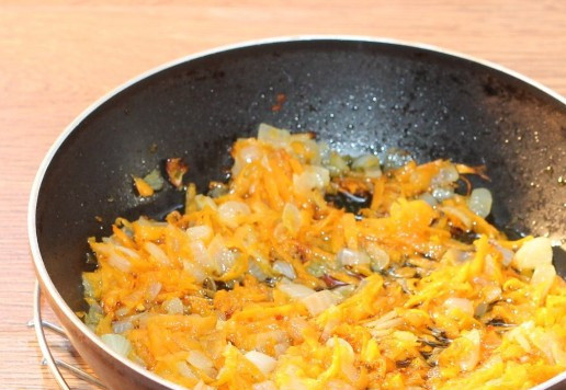 1. Этап. Cуп из куриных шеек с рисом: 5. Лук репчатый нарезать кубиками небольшого размера. Морковь натереть на крупной тёрке. Обжарить овощи на разогретом масле, 5 минут на умеренном огне.