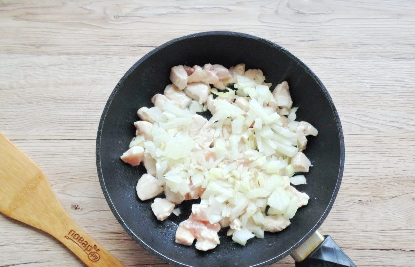 1. Этап. Жульен с курицей и грибами на сковороде: Лук очистите, ополосните и нарежьте мелко. Добавьте в сковороду к курице. Продолжайте жарить курицу с луком еще 5-6 минут.