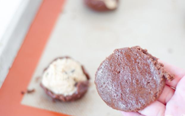 1. Этап. Шоколадное печенье с ванилью: 4. Сверху выложить еще столовую ложку теста, формируя лепешку, и закрыть верхушку шоколадного шарика. Повторить с оставшимся тестом.