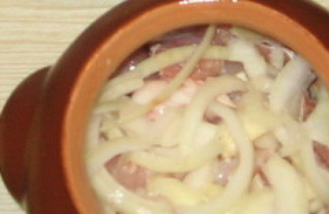 1. Этап. Жаркое из кролика в горшочках: Лук режем полукольцами, кладем сверху на мясо.