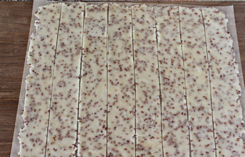 1. Этап. Постное галетное печенье: Вырезаем пергамент по размеру противня для запекания. Кладем на него тесто и раскатываем тонким слоем распределяя по всей поверхности.